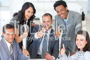 Happy businessteam with thumbs up in office