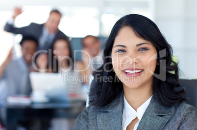 Businesswoman smiling with her team celebrating a success in the