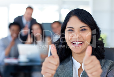 Portrait of a businesswoman with thumbs up in office