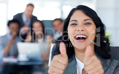 Happy businesswoman with thumbs up in office