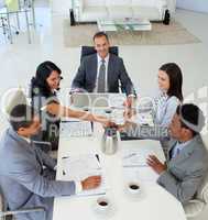 Businesswoman and businessman shaking hands in a meeting