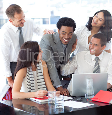Smiling multi-ethnic business team working with a laptop