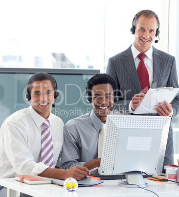 Manager talking to two businessmen in call center