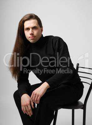 Young man with long hair in black