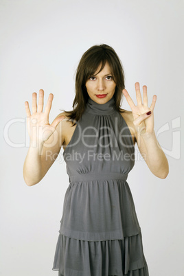 Eine junge Frau zeigt die Zahl neun an