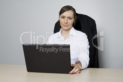Junge Geschäftsfrau sitzt vor ihrem Computer