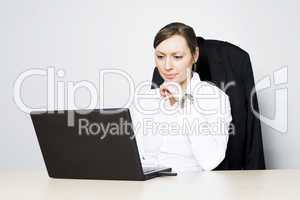 Junge Geschäftsfrau sitzt vor ihrem Computer
