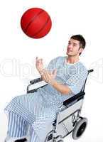 Patient in wheelchair having fun with a basket ball