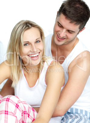 Man and woman sitting on bed