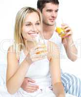 Lovers drinking orange juice in bed