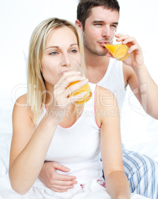 Couple drinking orange juice in bed