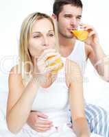 Couple drinking orange juice in bed