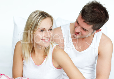 Man and woman sitting on bed together