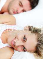 Beautiful smiling woman in bed with her boyfriend