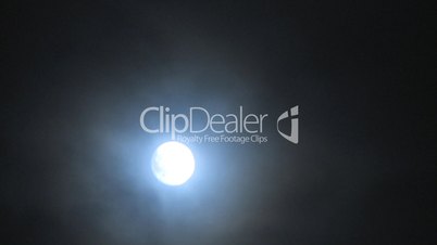 Time lapse moon rising through clouds