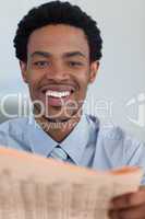 Afro-American businessman with a newspaper smiling at the camera