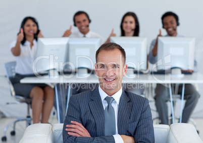 Manager in call center with his team with thumbs up