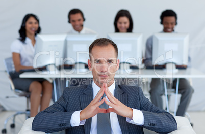 Manager sitting in call center in front of his team