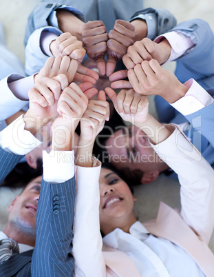 Business team on floor in a circle with thumbs up