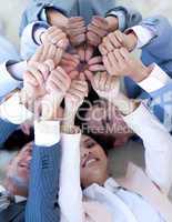 Business team on floor in a circle with thumbs up