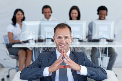 Smiling manager in call center in front of his team