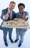 Architects holding a model house with thumbs up
