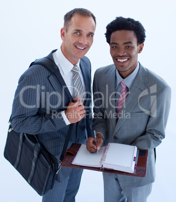 Smiling businessmen writing in a business diary