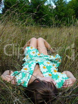 beautiful young girl lies on a grass