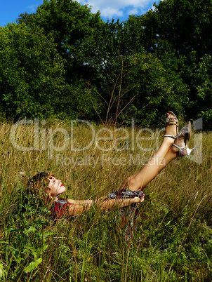 sexual beautiful girl has a rest on a grass in the afternoon