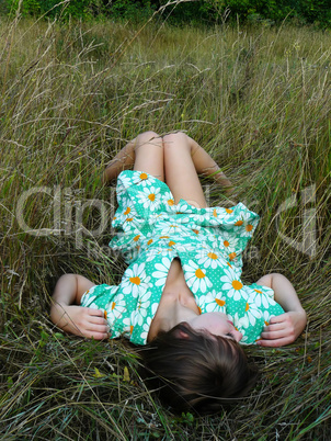 sexyal and beautiful young girl lies on a grass