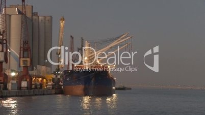 Huge cargo ship moving load at port
