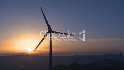 Wind turbine generator in the mountains at sunset