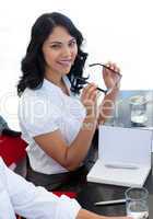 Lächelnde Geschäftsfrau hält ihre Brille in den Händen