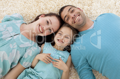 High angle of parents and daughter on floor with heads together