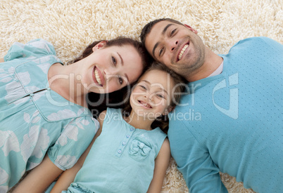 Smiling parents and girl on floor with heads together