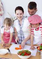 Happy family preparing a salad in kitchen