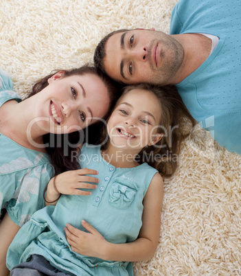 Portrait of parents and daughter on floor with heads together