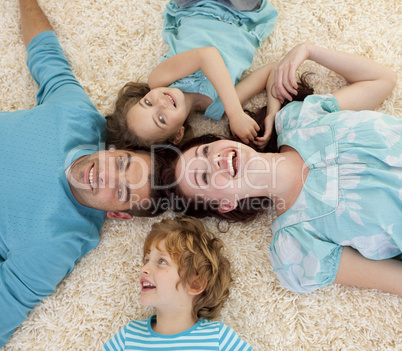 Smiling family on floor with heads together