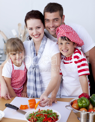 Family cutting colourful vegetables in kitchen