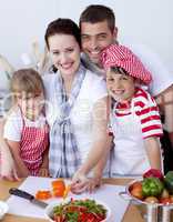 Family cutting colourful vegetables in kitchen