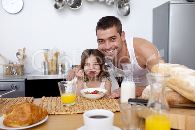 Daughter eating cereals and fruit in kitchen