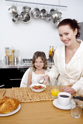 Little girl having breakfast with her mother