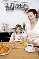 Little girl having breakfast with her mother