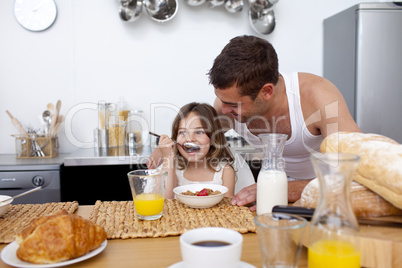 Daughter eating cereals and fruit for breakfast