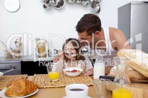 Little girl enjoying her breakfast with her father