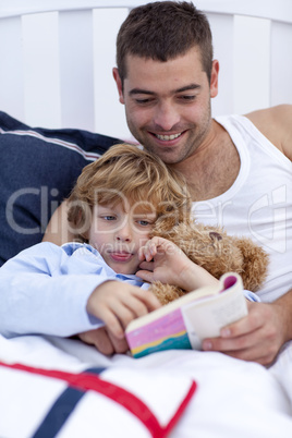 Little boy reading with his father a book