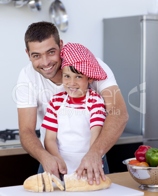 Smiling father and son cutting bread