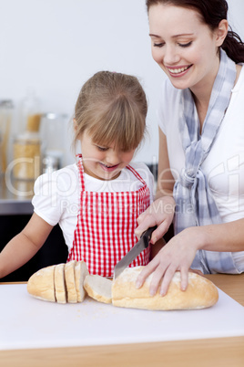 Mother and daughter cutting bread