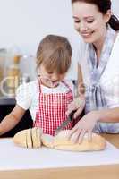 Mother and daughter cutting bread