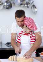 Father helping his son cutting bread